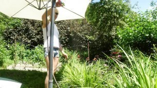 Alexa Cosmic trans girl wetting & wetlook in the garden in white t-shirt and denim shorts under water from a hose...