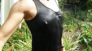 Refreshing & wetting t-shirt and black shorts in hose in the garden...